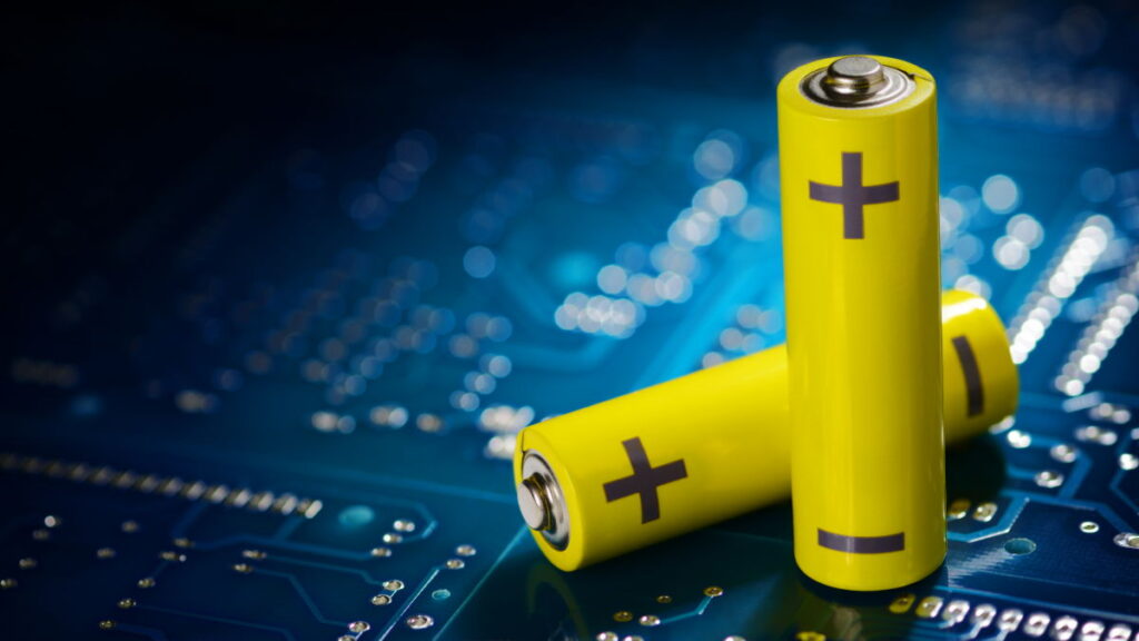 Yellow mignon AA batteries on the blue printed circuit board. Macro shot