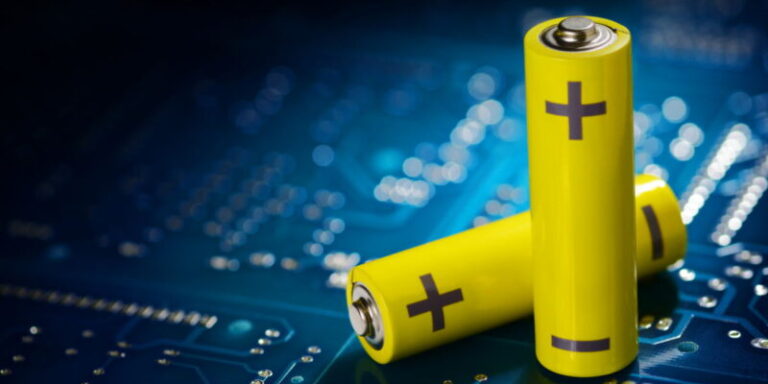 Yellow mignon AA batteries on the blue printed circuit board. Macro shot